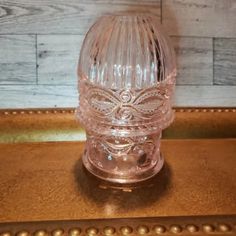 a clear glass vase sitting on top of a wooden table