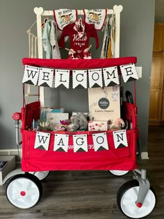 a red wagon with welcome wagon signs on it's sides and decorations hanging from the front