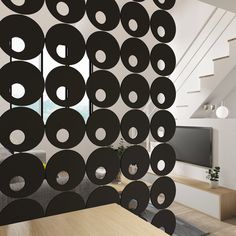 a living room filled with furniture and lots of black circles hanging from the ceiling over a wooden table