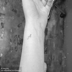 a woman's arm with a small tattoo on the left side of her wrist