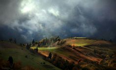 the rolling hills are covered in clouds and trees