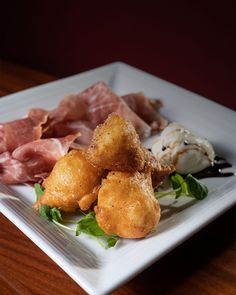 a white plate topped with food on top of a wooden table