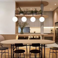 a dining room table with four chairs in front of an open kitchen and living area