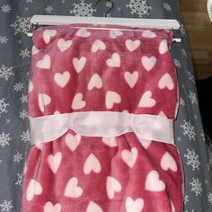 a blanket with hearts on it laying on a bed