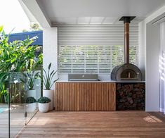 an outdoor kitchen with wood flooring and white walls