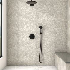 a bathroom with a black shower head and hand held shower faucet in it