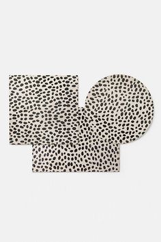 two placemats with black and white spots on them, one in the shape of an elephant