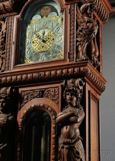 an ornate wooden clock with carved figures on it