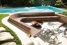 a wooden bench sitting next to a swimming pool