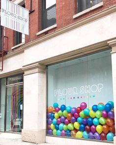 there is a store front with balloons in the window