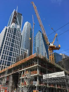 construction in the city with skyscrapers and cranes around it, including one large crane