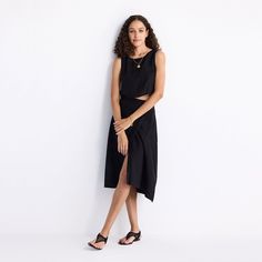 A welcome addition to your black wardrobe, this solid midi skirt with an overlap style and button detailing on the side lays out a versatile canvas for endless styling options. The skirt is crafted from Hemp fabric making it super comfy and breathable Chic Midi Skirt With Split Design, Chic Black Midi Dress, Black Midi Dress For Work, Spring Workwear Midi Dress With Asymmetrical Skirt, Chic Black Asymmetrical Wrap Skirt, Chic Wrap Skirt With High-low Hem, Chic High-low Hem Wrap Skirt, Black Asymmetrical Wrap Skirt For Summer, Chic Midi Length Wrap Skirt For Workwear