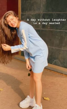 a woman with long hair standing in front of a blackboard