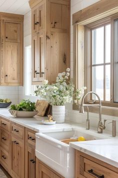 a kitchen filled with lots of wooden cabinets and white counter tops next to a window