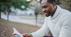 a man sitting on the ground reading a book