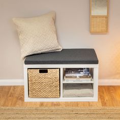 a white bench with two baskets under it and a pillow on the seat next to it