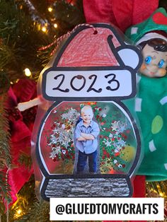 a christmas ornament hanging from a tree with a photo inside it and the name 2012