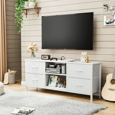 a flat screen tv mounted to the side of a white entertainment center in a living room