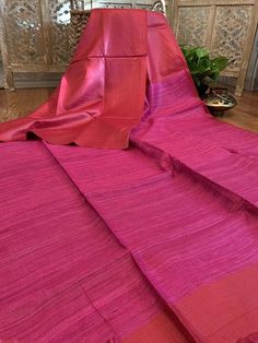 A bright and bold saree in staple cotton with a ghicha pallu. The color of the saree is a tomato red while the pallu (ghicha part) is fuchsia pink. The blouse piece is in stripes. Very smart saree, at the same time very comfortable. Condition: NewFabric: Staple cotton and ghicha Length: 5.5 metres Fall & Pico : Not done. Available on request. Blouse: Saree comes with running blouse piece. Customized stitching: available upon request with additional charges. Occasion: Party, Festive, WeddingN Red Slub Silk Pre-draped Saree With Cutdana, Red Cotton Silk Pre-draped Saree For Diwali, Red Cotton Silk Pre-draped Saree, Red Slub Silk Saree With Unstitched Blouse, Diwali Red Slub Silk Saree, Unstitched Red Cotton Silk Saree, Red Tussar Silk Saree With Unstitched Blouse, Red Slub Silk Saree For Puja, Red Slub Silk Saree