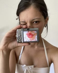 a woman taking a selfie with her cell phone in front of her face and wearing a bra