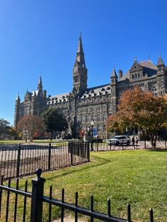 the large building has many spires on it's roof and is surrounded by green grass