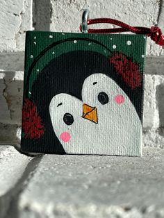 a painting of a penguin with a red bow on it's head and nose