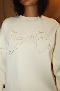 Add a touch of whimsy to your wardrobe with our cream embroidered ribbon crewneck sweatshirt. This coquette sweatshirt is both cute and playful, making it a fun addition to any outfit. Perfect for those who don't take themselves too seriously. adult size Coquette Crewneck, Girly Sweatshirt, Curvy Date Night Outfit, Coquette Sweatshirt, Air Clothes, Cream Crewneck, Cream Sweatshirt, Embroidery Crewneck, Embroidered Bow