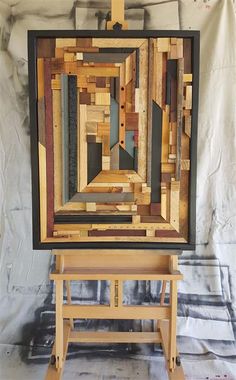 a piece of art made out of wood sitting on top of a wooden easel