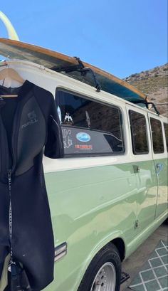 a green van with a surfboard on top of it