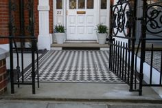 a black and white checkered tile floor in front of a door with wrought iron gates