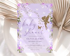 the baby shower is decorated with purple flowers and gold glitters, as well as a fairy