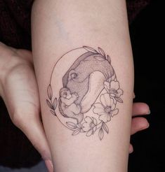 a woman's thigh with a tattoo of a pig and flowers on the side