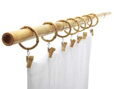 a bamboo curtain rod with wooden rings hanging from it