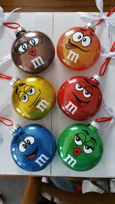 four ornaments with different colored faces on them