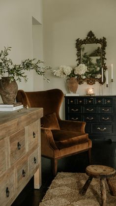 a living room filled with furniture and a wooden dresser next to a mirror on the wall