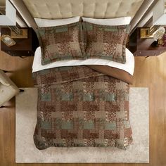 an overhead view of a bed with brown and green bedspread, pillows and headboard