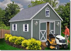 a small green barn with two doors and windows on the side, is shown in front of a white background