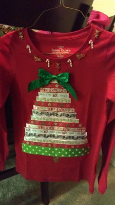 a red shirt with a christmas tree on the front and green bow at the neck