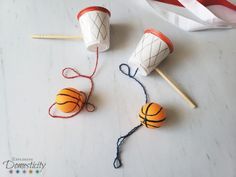 some balls and sticks are sitting on the table next to each other with yarn wrapped around them