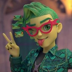 a doll with green hair and red glasses making the peace sign while holding up her fingers