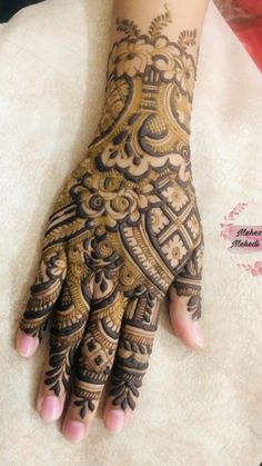 a woman's hand is decorated with hennap and intricate designs on it