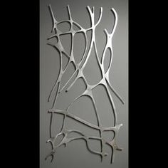 an abstract piece of art made out of metal branches on a gray background with black and white text