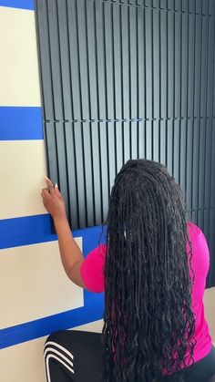 a woman writing on a wall with blue and white stripes