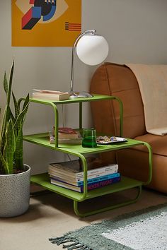 a green shelf sitting next to a couch in a living room with a lamp on top of it