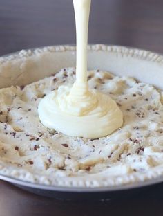 a bowl filled with mashed potatoes topped with a white sauce drizzled on top