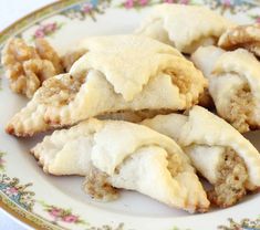 several pastries are on a plate with flowers and leaves around the edges, ready to be eaten