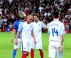 two soccer players are talking to each other in front of an audience at a sporting event