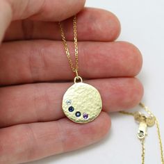 "Unique and personalized, this mother's necklace is handcrafted from 14k yellow gold and features 4 birthstones of your choice. (Price varies depending on stone combination.) Fabricated by hand using scrap 14ky gold that is melted into a chunk and hammered flat, through a process of hammering the metal to flatten it and heating the metal to soften it (annealing)....hammering and heating until the metal is 5/8\" in diameter. A hole is drilled where each stone will be set, and the surface is given Yellow Gold Sterling Silver Birthstone Necklace With Round Stone, 14k Yellow Gold Birthstone Necklace With Round Pendant, Yellow Gold Birthstone Necklace In Recycled Gold, Yellow Gold Birthstone Necklace With Round Sterling Silver Pendant, Yellow Gold Sterling Silver Birthstone Necklace With Round Pendant, Hallmarked Yellow Gold Birthstone Necklace Gift, Round 14k Gold Emerald Birthstone Necklace, Recycled Gold Round Birthstone Necklaces, Recycled Gold Gemstone Birthstone Necklace As A Gift