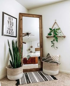 a living room with a large mirror and some plants in baskets on the floor next to it