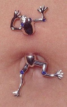 two silver colored earrings with blue stones on the bottom and one is shaped like a frog